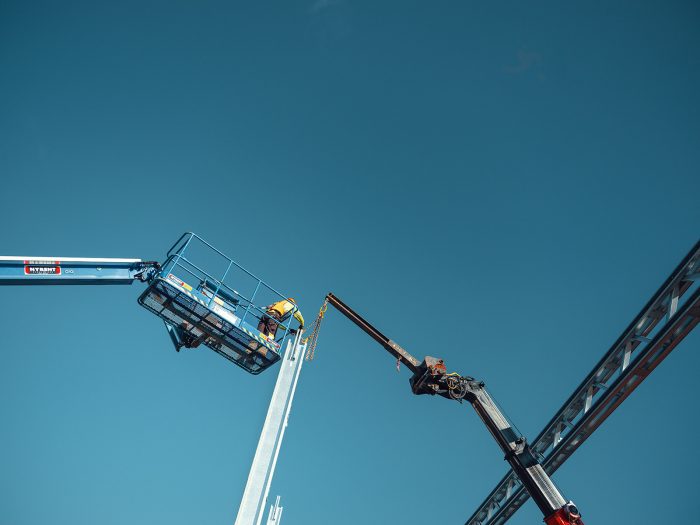 Byggarbetare som arbetar på hög höjd i lift.