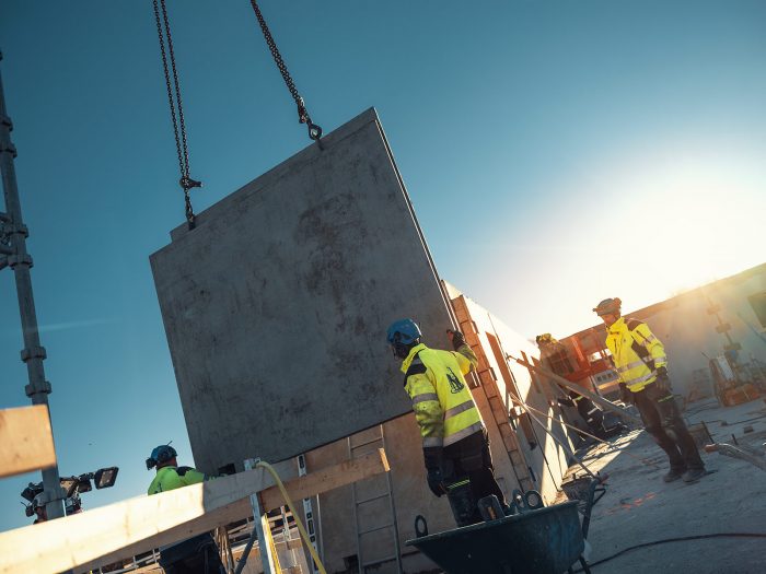 Byggnadsarbetare med skyddshjälm och handskar som personlig skyddsutrustning.