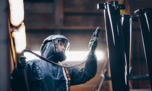 Person som arbetar med sprutmålning använder andningsskydd för att vara säker på jobbet.