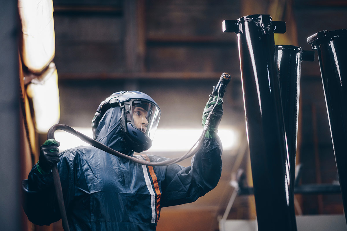 Person som arbetar med sprutmålning använder andningsskydd för att vara säker på jobbet.